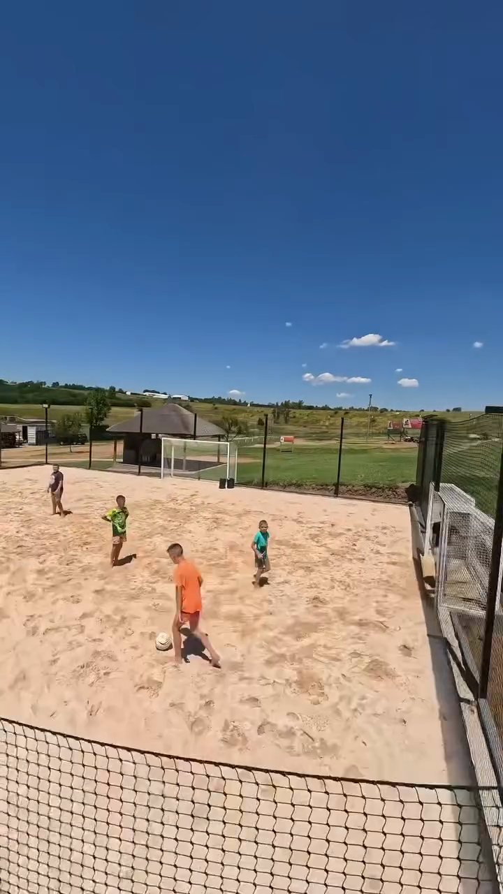 Kids playing on the beach soccer court