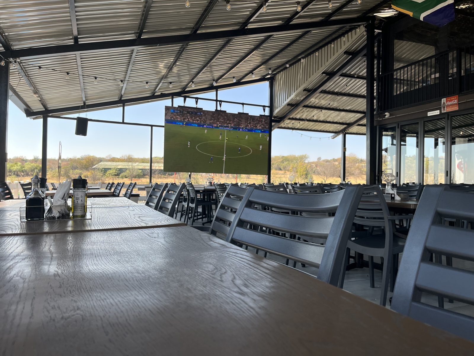 Covered deck with the big screen on for the game